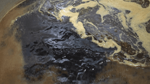 Foamy black soy sauce broth boiling