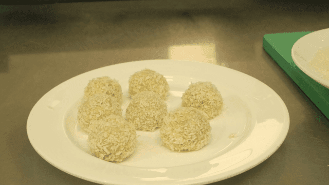 Breaded balls on a white plate in a kitchen