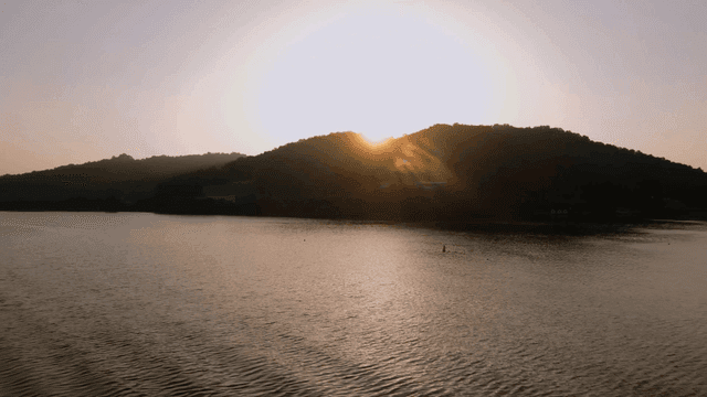 Sunset over a calm lake with hills