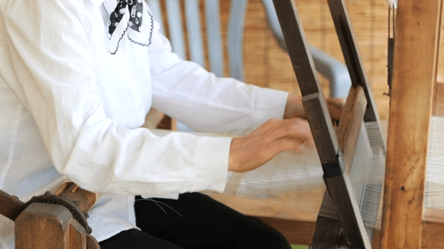 실내에서 전통 베틀로 직조하는 모습