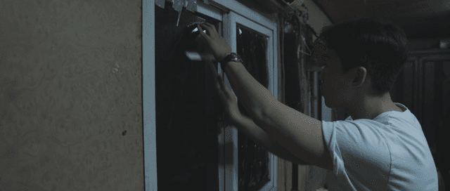 Man attaching a blackout sheet to a window