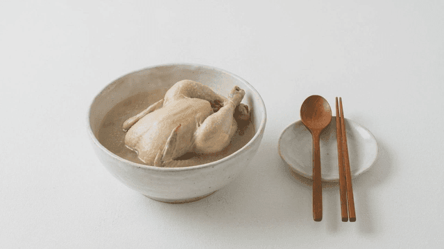 A bowl of samgyetang with utensils