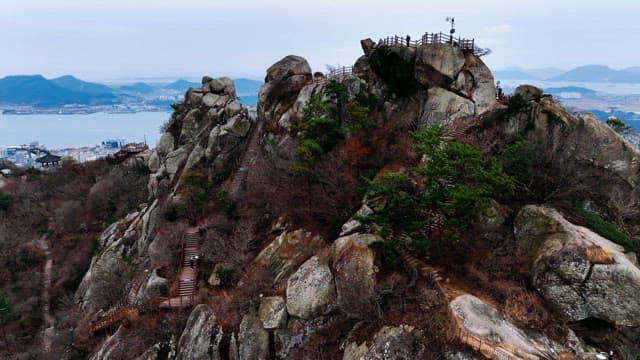 Mountain with rocky paths and distant city view