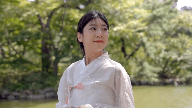 연못가에 서 있는 한복 입은 여성
