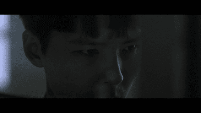Student concentrating in dark classroom