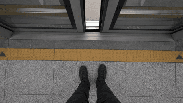 Shoes in front of subway screen doors