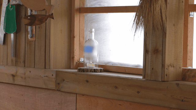 나무 창틀 위의 병 속 촛불