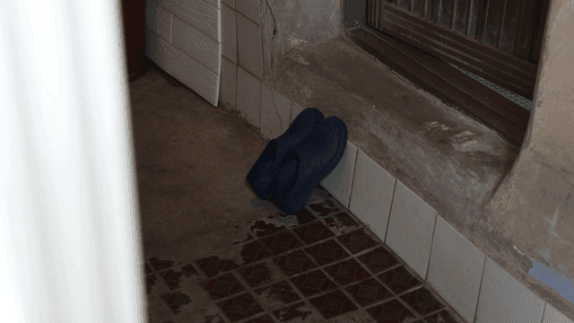 Pair of blue shoes by a tiled wall