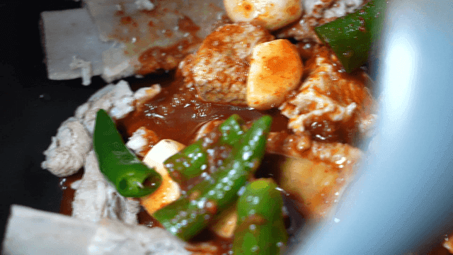 Spicy braised rib sauce poured over ribs with chili and garlic