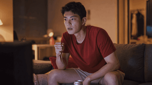 A man watching TV intently at home