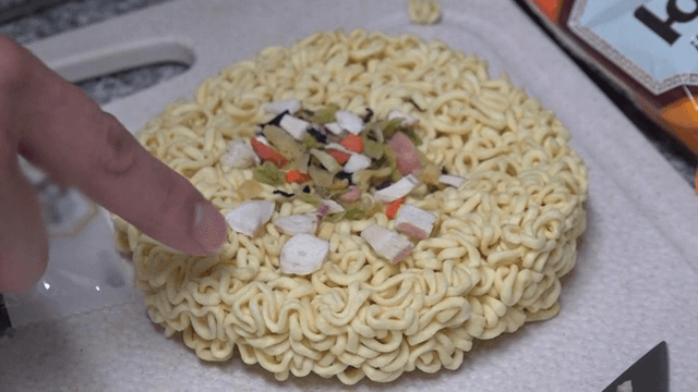 라면 위의 후레이크를 가르키는 손가락