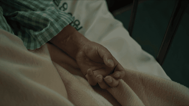Patient's hand on hospital bed