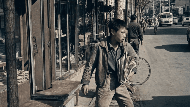 Youth newspaper deliveryman on streets in 70s