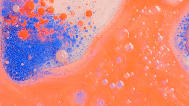 Abstract pattern of red and orange liquids mixing together