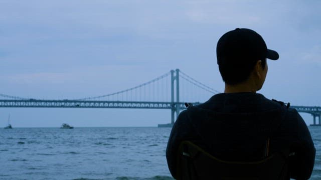 Contemplative Man Looking at the Sea on a Cloudy Day