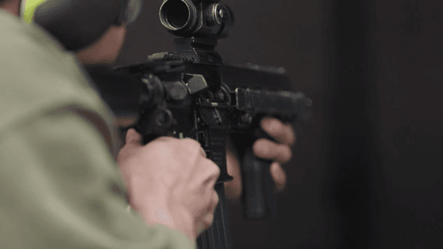 실내에서 소총을 겨누는 사람