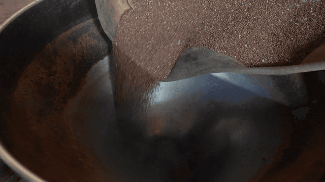 Perilla seeds poured into large metal pot