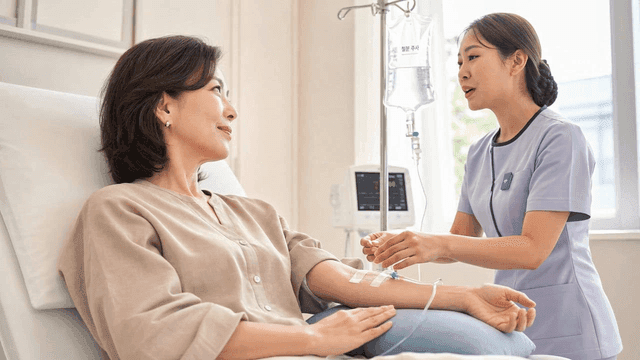 Middle-aged female patient receiving intravenous fluid therapy at hospital