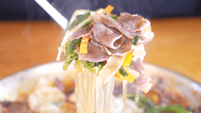 Ladle full of stew with vegetables and meat