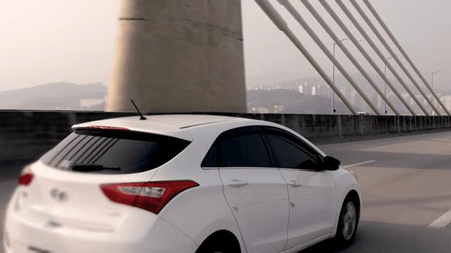 White car driving on a bridge