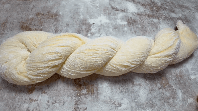 밀가루를 뿌린 표면 위의 꼬인 반죽