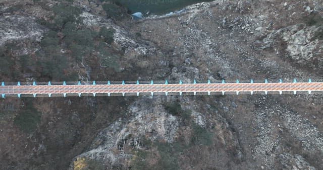 산의 협곡을 가로지르는 출렁다리의 경치