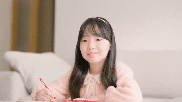 실내에서 그림을 그리다가 미소 짓는 어린 소녀