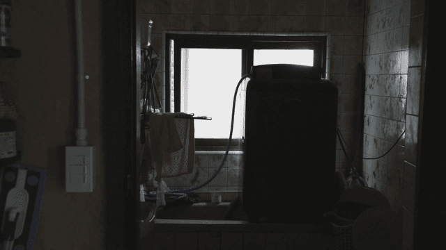 Dimly lit laundry room with a window
