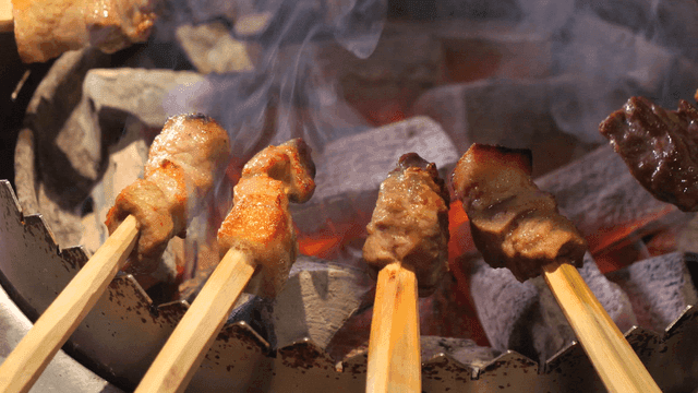 Primitive skewer grilling over charcoal with dripping oil