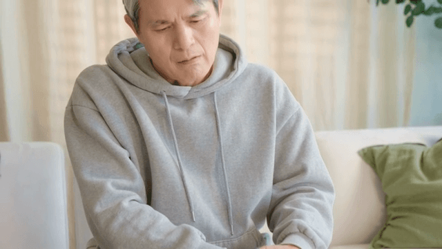 무릎을 잡고 불편해하는 남성