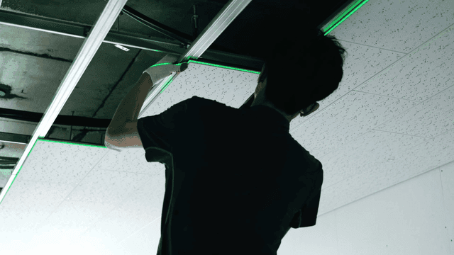 Worker installing ceiling panels indoors
