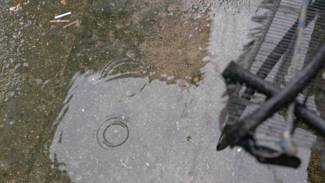 Puddles on wet ground on a cement floor on a rainy day