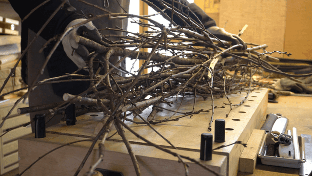 작업대에 나뭇가지들을 올리는 목공예가