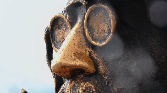 안경을 쓴 안톤 체홉의 청동 조각상