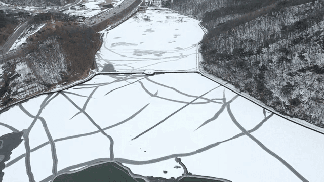 눈 덮인 숲으로 둘러싸인 얼어붙은 호수