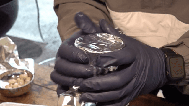 Wrapping bamboo with foil using gloved hands