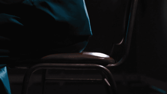 Person sitting on chair in dark room