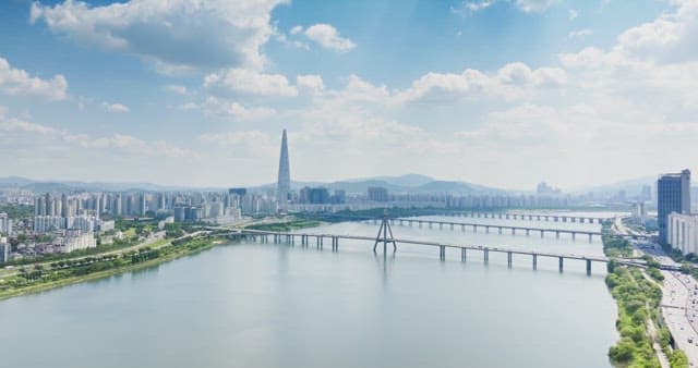 Cityscape with river and high-rise buildings under clear sky