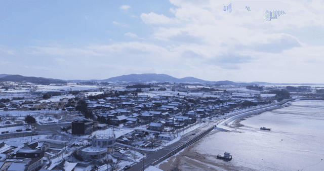 Snow-covered traditional Hanok village by sea