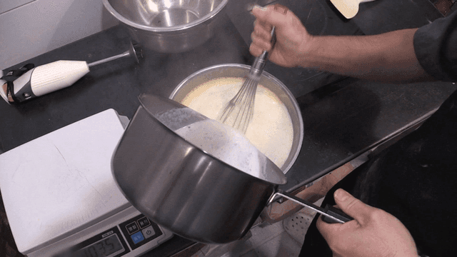 밀가루 반죽에 뜨거운 우유를 부어가며 젓는 제빵사