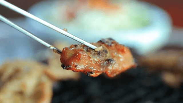 젓가락으로 집어 올리는 구운 갈비