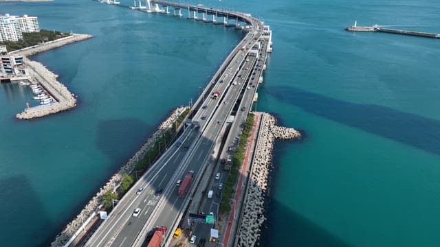 도시 스카이라인이 보이는 바다 위 다리