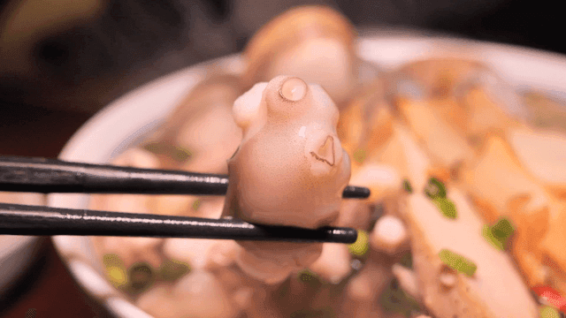 Nourishing seafood rice noodles with octopus picked up with chopsticks