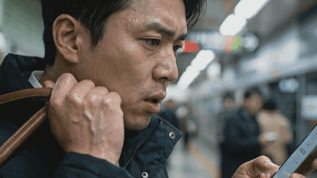 Man checking phone on subway platform