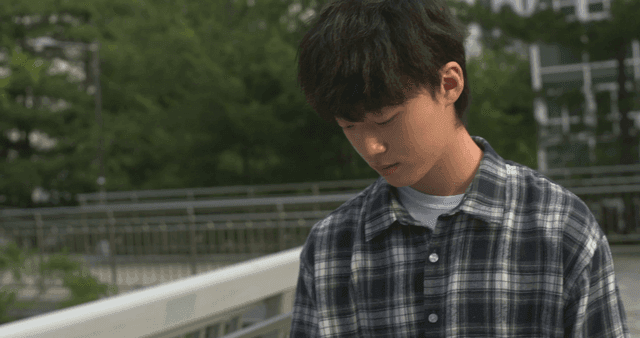 Gloomy young man walking on bridge