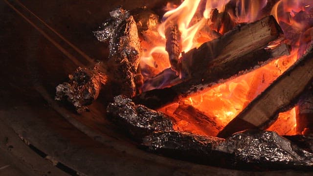 밤을 밝히며 활활 타오르는 모닥불에서 군고구마 굽기