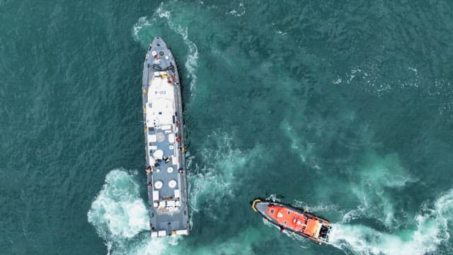 바다 위의 큰 선박으로 향하는 해양 경비정