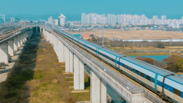 High-speed train passing through city landscape.