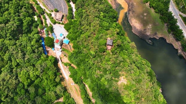 Aerial view of a green forest and traditional pavilion