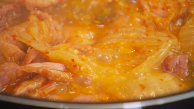 Cooking spicy kimchi stew with smoked duck